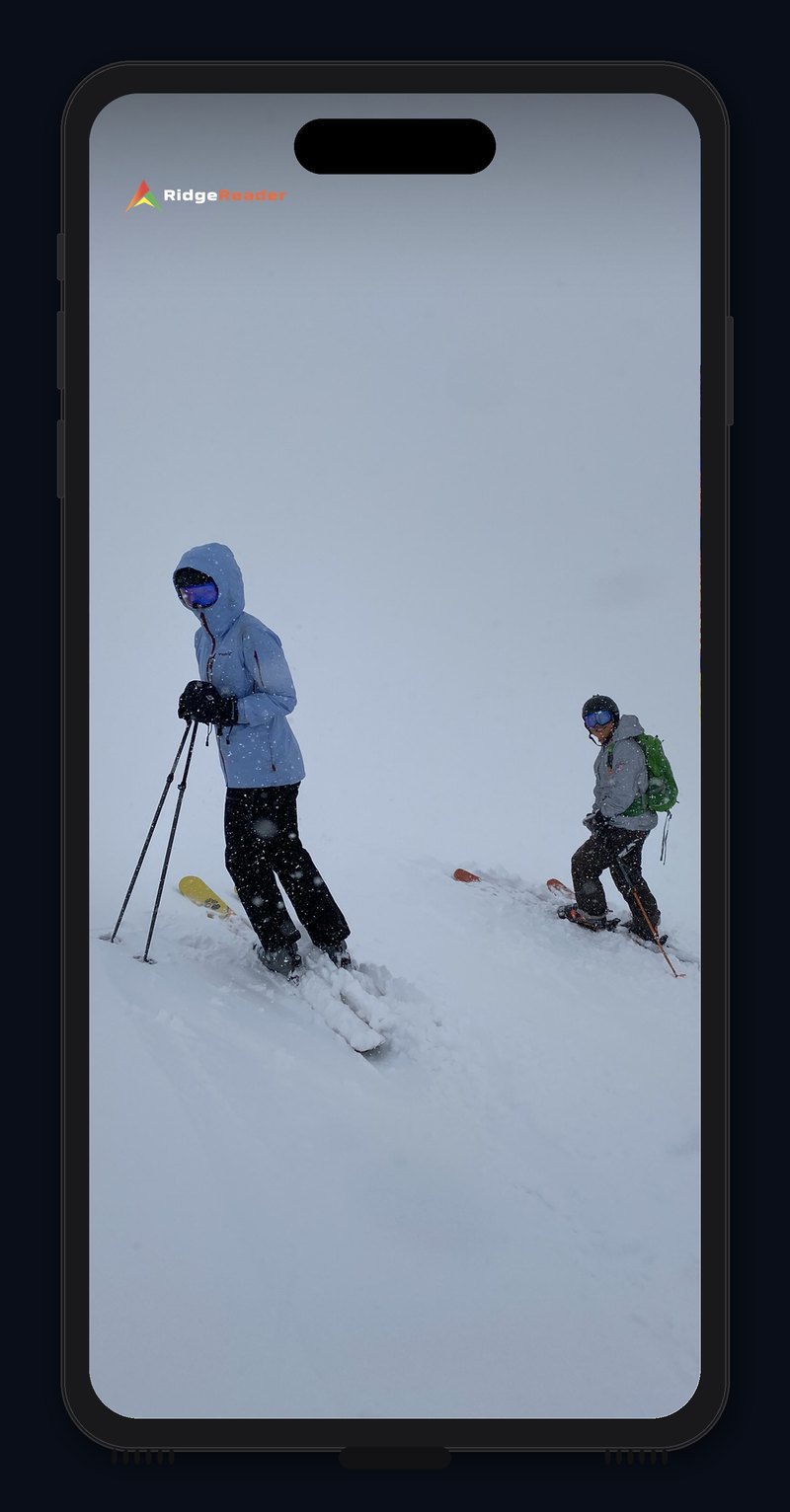 The RidgeReader camera view of two skiers in a whiteout near Breckenridge. Slope-angle shading fades in over the terrain the fog is hiding.